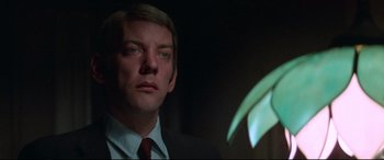 Movie still from “Klute” (1971), directed by Alan J. Pakula – A person wearing a suit and tie; Close Up shot, Low angle