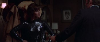 Movie still from “Klute” (1971), directed by Alan J. Pakula – A woman in a black dress holding a man's hand; Medium shot, Over the shoulder angle