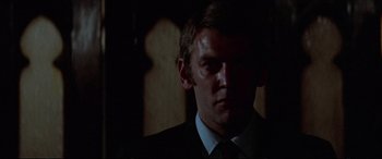 Movie still from “Klute” (1971), directed by Alan J. Pakula – A person wearing a suit and tie; Close Up shot, Low angle