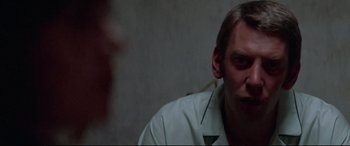 Movie still from “Klute” (1971), directed by Alan J. Pakula – A person sitting in front of a wall; Close Up shot, Over the shoulder angle