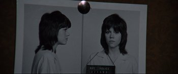 Movie still from “Klute” (1971), directed by Alan J. Pakula – Two women are shown in front of a police photo; Close Up shot, Low angle
