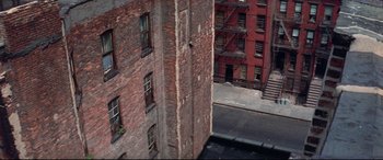 Movie still from “Klute” (1971), directed by Alan J. Pakula – An aerial view of an old brick building with fire escapes; Extreme Wide shot, Overhead angle