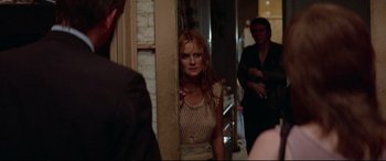 Movie still from “Klute” (1971), directed by Alan J. Pakula – A woman standing next to a man in front of a mirror; Medium shot, Over the shoulder angle