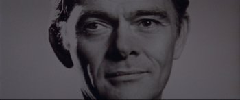 Movie still from “Klute” (1971), directed by Alan J. Pakula – An old black and white photo of a man's face; Extreme Close Up shot, Low angle