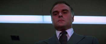 Movie still from “Klute” (1971), directed by Alan J. Pakula – A person wearing a suit and tie; Close Up shot, Low angle