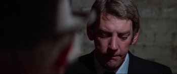 Movie still from “Klute” (1971), directed by Alan J. Pakula – A person wearing a suit and tie; Close Up shot, Over the shoulder angle