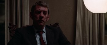 Movie still from “Klute” (1971), directed by Alan J. Pakula – A person wearing a suit and tie; Close Up shot, Low angle