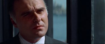 Movie still from “Klute” (1971), directed by Alan J. Pakula – A person wearing a suit and tie; Close Up shot, Low angle