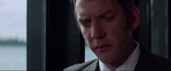 Movie still from “Klute” (1971), directed by Alan J. Pakula – A person wearing a suit and tie; Close Up shot, Low angle