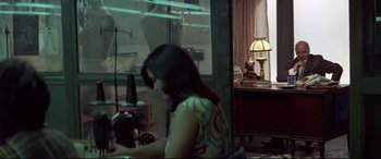Movie still from “Klute” (1971), directed by Alan J. Pakula – A woman sitting in front of a window with a lamp; Medium shot, Over the shoulder angle