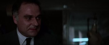 Movie still from “Klute” (1971), directed by Alan J. Pakula – A person wearing a suit and tie; Close Up shot, Low angle