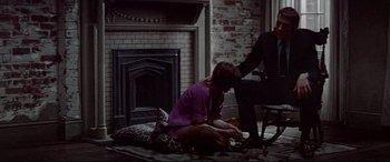 Movie still from “Klute” (1971), directed by Alan J. Pakula – A woman sitting on the floor next to a fireplace; Wide shot, High angle