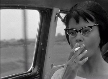 Movie still from “Knife in the Water” (1962), directed by Roman Polanski – A black and white photo of a woman eating a sandwich; Close Up shot, Low angle