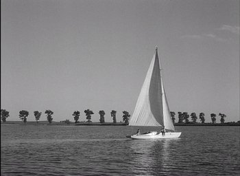Movie still from “Knife in the Water” (1962), directed by Roman Polanski – A sailboat sailing on a body of water; Extreme Wide shot, High angle