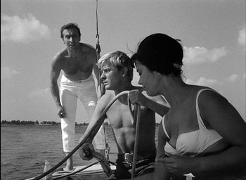 Movie still from “Knife in the Water” (1962), directed by Roman Polanski – A man and a woman on a boat with two other people; Medium shot, Low angle