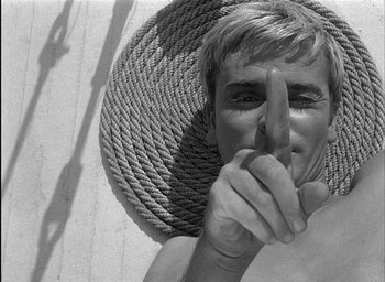 Movie still from “Knife in the Water” (1962), directed by Roman Polanski – A man with his finger over his mouth; Close Up shot, Overhead angle
