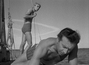 Movie still from “Knife in the Water” (1962), directed by Roman Polanski – A man and a woman on a sailboat in the ocean; Medium shot, Low angle