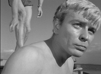 Movie still from “Knife in the Water” (1962), directed by Roman Polanski – A black - and - white photo of a shirtless man; Close Up shot, Low angle