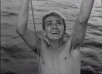 Movie still from “Knife in the Water” (1962), directed by Roman Polanski – A young man holding a rope in the water; Close Up shot, High angle