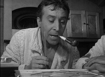 Movie still from “Knife in the Water” (1962), directed by Roman Polanski – A man is painting with a paintbrush in his mouth; Close Up shot, High angle