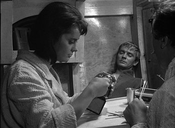 Movie still from “Knife in the Water” (1962), directed by Roman Polanski – A man and a woman in front of a bathroom mirror; Medium shot, High angle