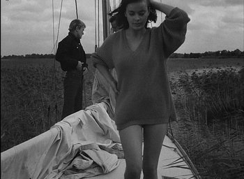 Movie still from “Knife in the Water” (1962), directed by Roman Polanski – A man and a woman standing on a boat in a field; Medium shot, High angle