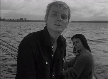 Movie still from “Knife in the Water” (1962), directed by Roman Polanski – A man and a woman standing in front of a body of water; Close Up shot, Low angle