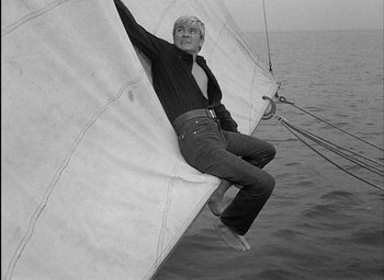 Movie still from “Knife in the Water” (1962), directed by Roman Polanski – A man hanging from a sail on a sail boat; Medium shot, Low angle