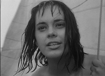 Movie still from “Knife in the Water” (1962), directed by Roman Polanski – A black - and - white photo of a woman holding an umbrella; Close Up shot, Low angle