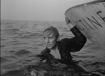 Movie still from “Knife in the Water” (1962), directed by Roman Polanski – A man in the water holding a surfboard; Medium shot, High angle