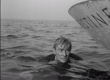 Movie still from “Knife in the Water” (1962), directed by Roman Polanski – A man in the water next to a boat in the ocean; Medium shot, High angle