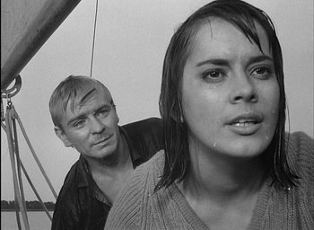 Movie still from “Knife in the Water” (1962), directed by Roman Polanski – A man and a woman standing next to each other; Close Up shot, Over the shoulder angle