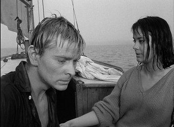Movie still from “Knife in the Water” (1962), directed by Roman Polanski – A man and a woman on a sailboat in the ocean; Close Up shot, High angle