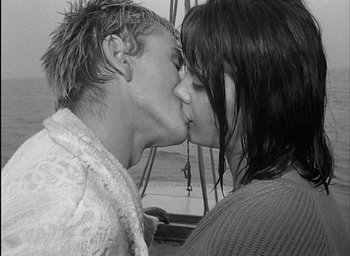 Movie still from “Knife in the Water” (1962), directed by Roman Polanski – A man and a woman kissing each other; Close Up shot, High angle