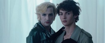 Two young men standing next to each other in a room