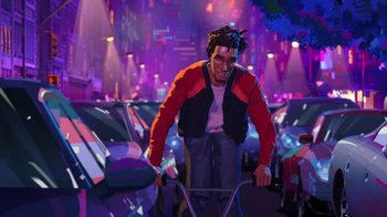 Movie still from “Entergalactic” (2022), directed by Fletcher Moules – A man riding a bike through a parking lot filled with parked cars; Wide shot, Low angle