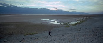 Movie still from “Knight of Cups” (2015), directed by Terrence Malick – A man walking across a dry lake bed; Extreme Wide shot, High angle