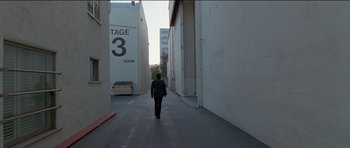 Movie still from “Knight of Cups” (2015), directed by Terrence Malick – A man walking down a street in an alleyway; Extreme Wide shot, High angle