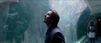 Movie still from “Knight of Cups” (2015), directed by Terrence Malick – A man standing in front of a waterfall looking up; Medium shot, Low angle