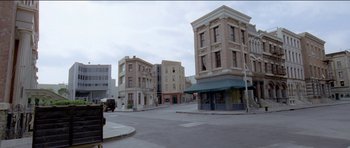 Movie still from “Knight of Cups” (2015), directed by Terrence Malick – An empty street in a large city with many tall buildings on both sides of the street; Extreme Wide shot, High angle
