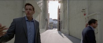 Movie still from “Knight of Cups” (2015), directed by Terrence Malick – A man in a suit standing in an alley way; Medium shot, Low angle