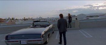 Movie still from “Knight of Cups” (2015), directed by Terrence Malick – A man and a woman standing in front of a car; Wide shot, Low angle