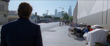 Movie still from “Knight of Cups” (2015), directed by Terrence Malick – A street scene with a man walking down the sidewalk; Wide shot, Over the shoulder angle