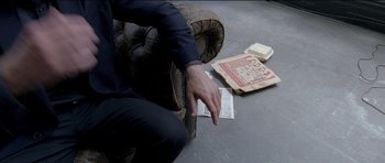 Movie still from “Knight of Cups” (2015), directed by Terrence Malick – A man sitting on a chair with a book on the floor; Extreme Close Up shot, High angle