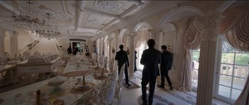Movie still from “Knight of Cups” (2015), directed by Terrence Malick – A group of people standing around a dining room table; Wide shot, High angle
