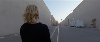 Movie still from “Knight of Cups” (2015), directed by Terrence Malick – A woman standing in the middle of an empty street; Wide shot, Over the shoulder angle