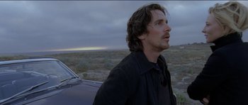 Movie still from “Knight of Cups” (2015), directed by Terrence Malick – A man standing next to a car in a field; Close Up shot, Over the shoulder angle