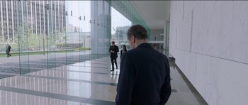 Movie still from “Knight of Cups” (2015), directed by Terrence Malick – A man in a black jacket is standing in front of two other people; Wide shot, Over the shoulder angle