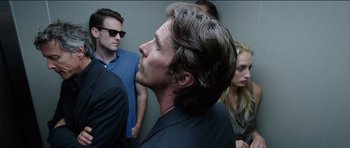 Movie still from “Knight of Cups” (2015), directed by Terrence Malick – A group of people standing next to each other in a room; Close Up shot, Over the shoulder angle