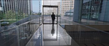 Movie still from “Knight of Cups” (2015), directed by Terrence Malick – A man in a suit is standing in front of a building; Extreme Wide shot, High angle